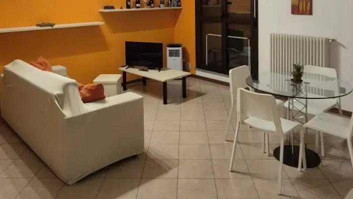 Soggiorno con muro arancione e divano